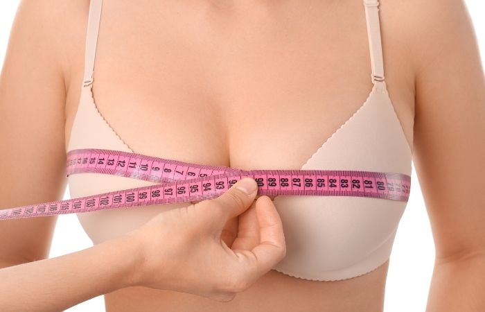una mujer midiendo su contorno de pecho Aumento de pechos mujeres