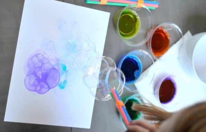 soplando burbujas de colores sobre un papel burbujas de colores