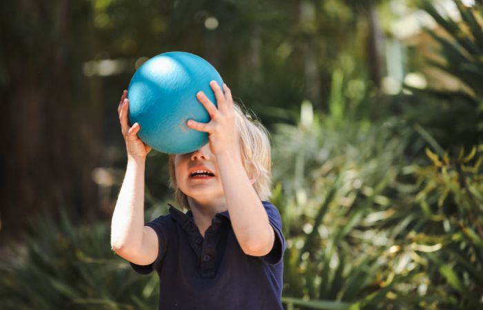 niño cogiendo un balón Juegos tradicionales balón prisionero