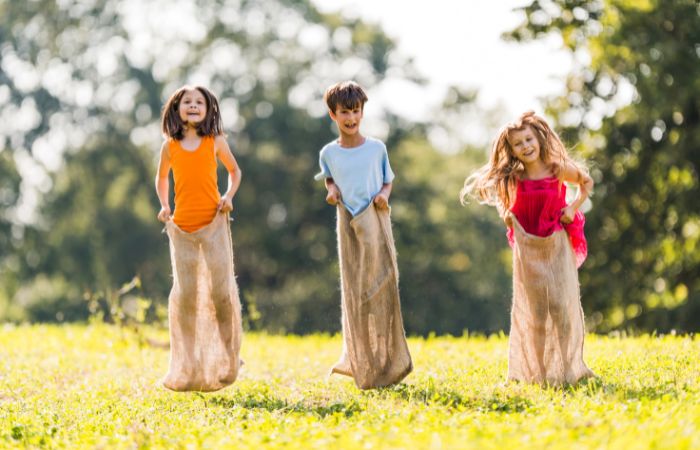 niños jugando a carrera de sacos Carrera de sacos
