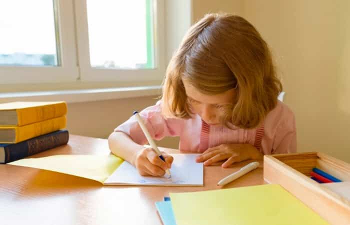coger el lápiz correctamente. Niña escribiendo