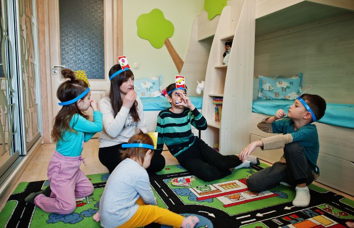 Niños y madre con juego de adivinanzas Juego de adivinanzas con papelitos