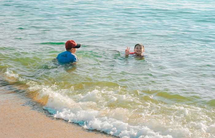 dos niños jugando al juego del ancla en el agua del mar Juego del ancla