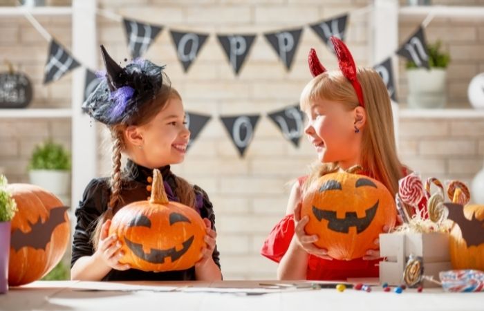 Precauciones en la decoración de Halloween Niñas decorando su casa por Halloween