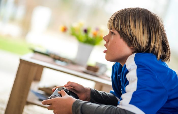 Niños jugando a videojuego con espalda adelantada y hombros encogidos Malas posturas jugando a videojuegos