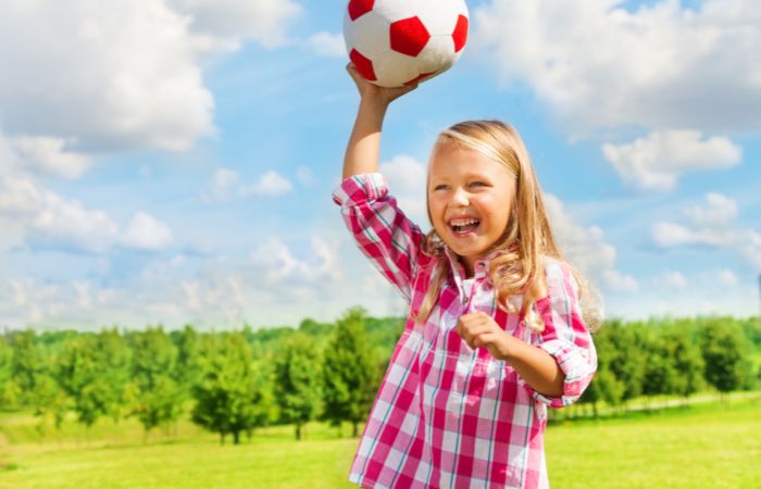 Niña a punto de lanzar una pelota en el juego del balón prisionero Juegos de pelota: balón prisionero
