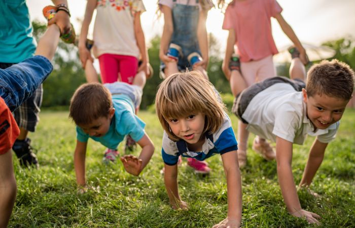 niños jugando a la carretilla en el parque la carretilla La carretilla