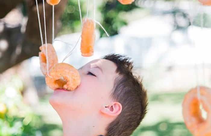 juegos al aire libre: alcanzar los donuts con la boca sin usar las manos Caza la rosquilla