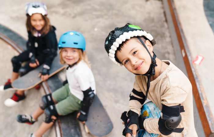 Deportes sobre ruedas: Niños con monopatín y protecciones Deportes sobre ruedas: el monopatín