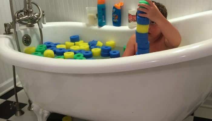 juegos de baño para niños con churros de piscina En la bañera jugando con churros de piscina cortados