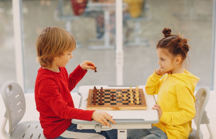 Un niño y una niña jugando al ajedrez Competitividad sana en el juego