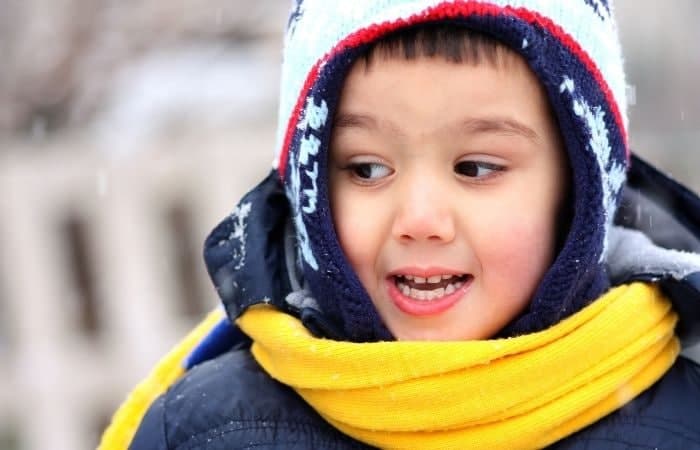 niño abrigado en la calle niño abrigado en la calle