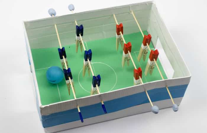 futbolín hecho en una caja de zapatos con brochetas de madera y pinzas de la ropa Futbolín en una caja