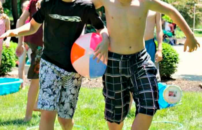 Juegos colaborativos al aire libre: sostener la pelota con la cadera Juegos colaborativos: relevos en la playa o en la psicina