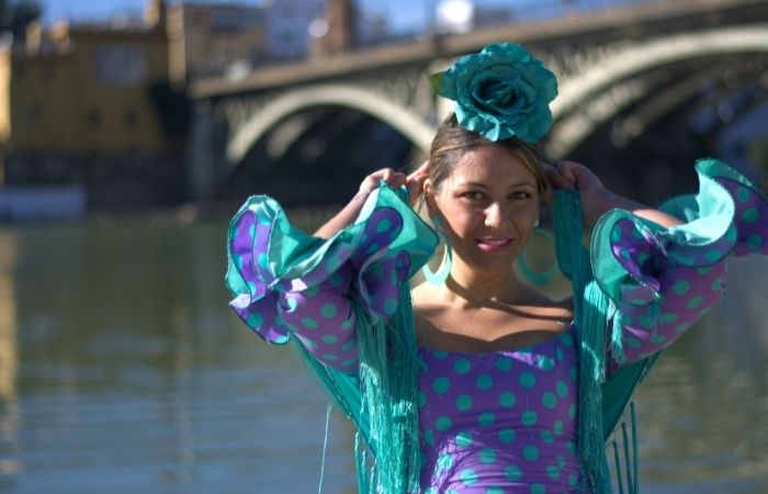Vestida de flamenca y junto al río feria de abril con niños: joven vestida de flamenca