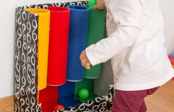 Juguete casero con tubos de colores y pelotas Juguete con tubos de colores para bebés