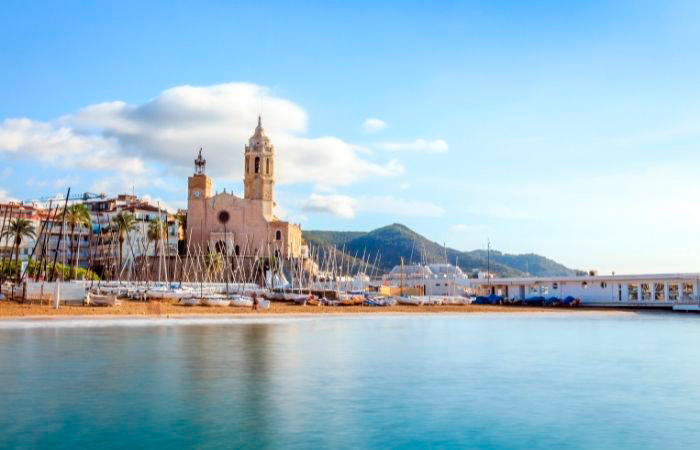 Playa de Sitges con la iglesia al fondo. Paddle Surf