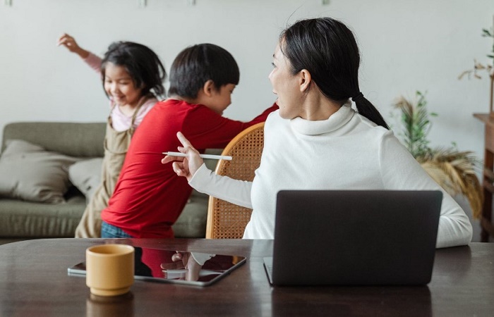 Pedir disculpas a nuestros hijos. Madre reprende a sus hijos Madre trabajando en casa reprende a niños que están alborotando. Pedir perdón a nuestros hijos beneficios