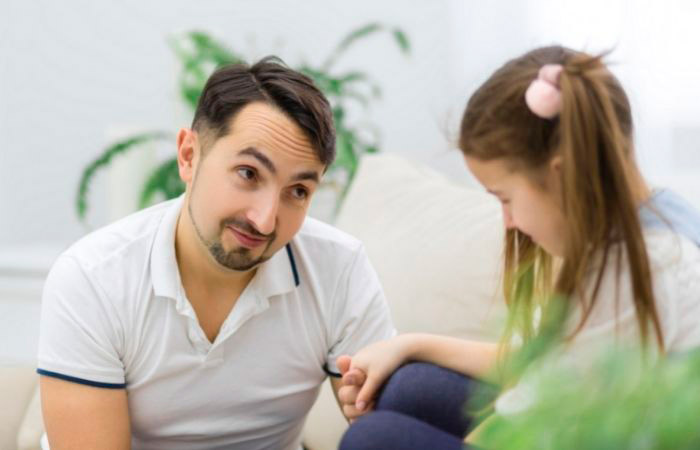 Padre pidiendo perdón a su hija Padre toma la mano de su hija y la mira con cariño mientras se disculpa