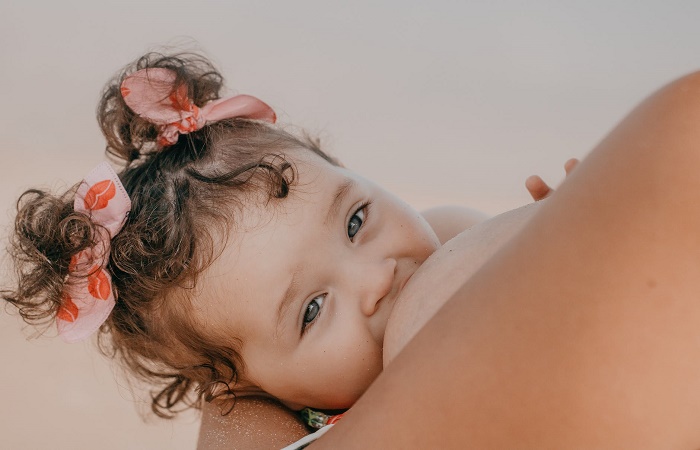 niña mamando del pecho de su madre Aumento de pechos madres