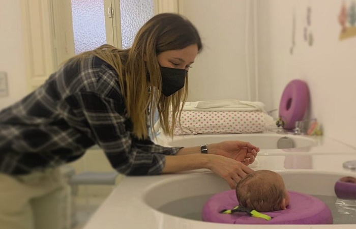 Beneficios de la hidroterapia para bebés Bebé con cuidadora en un spa. Hidroterapia para bebés