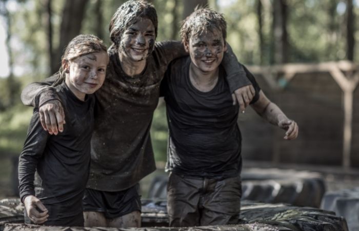 Jugar con barro es todo un placer para los niños Tres niños manchados enteros de barro. Beneficios de jugar con barro