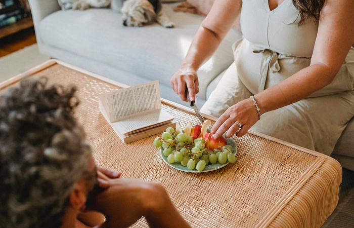 La alimentación saludable en el embarazo ayuda a la buena salud del bebé Embarazada comiendo fruta. Paladar hendido bebé