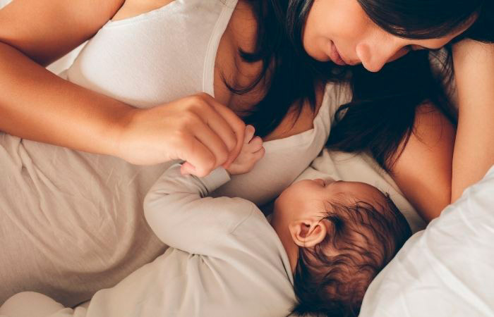 Madre en la cama con su bebé. Dónde deben dormir los bebés