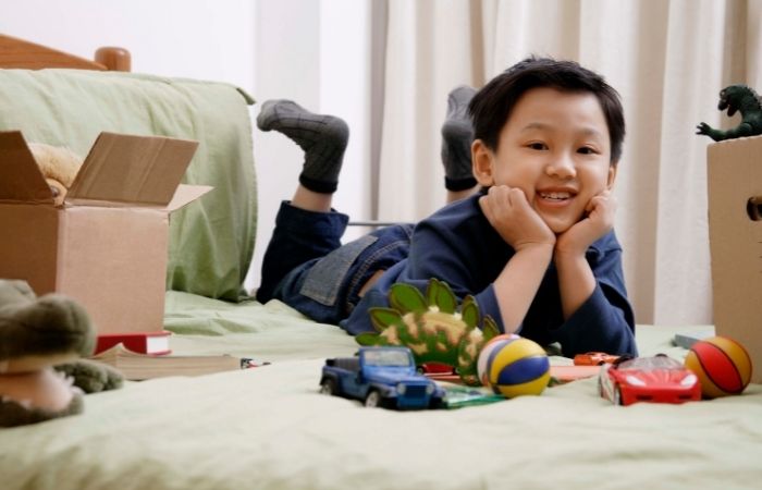 clasificar juguetes puede ser divertido Niños sobre la cama con varios juguetes