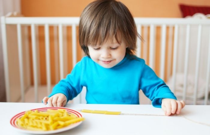 Ensartar macarrones Niños ensartando macarrones en un cordel. Ideas para entretener a los niños
