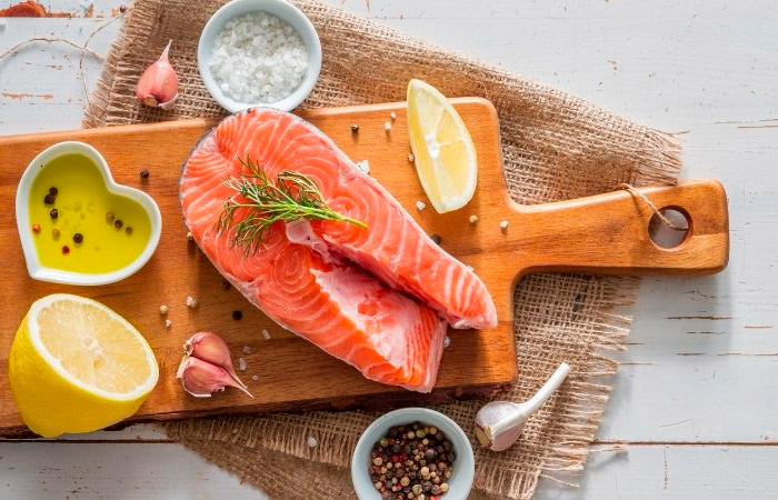 Salmón fresco, rico en Omega-3 Bodegón con tabla con rodaja de salmón fresco