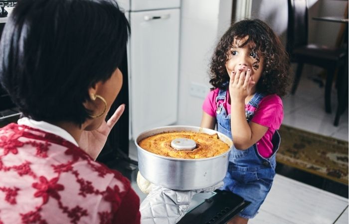 Madre dando de comer a su hija con sinestesia Niña sinestésica explorando sus sensaciones