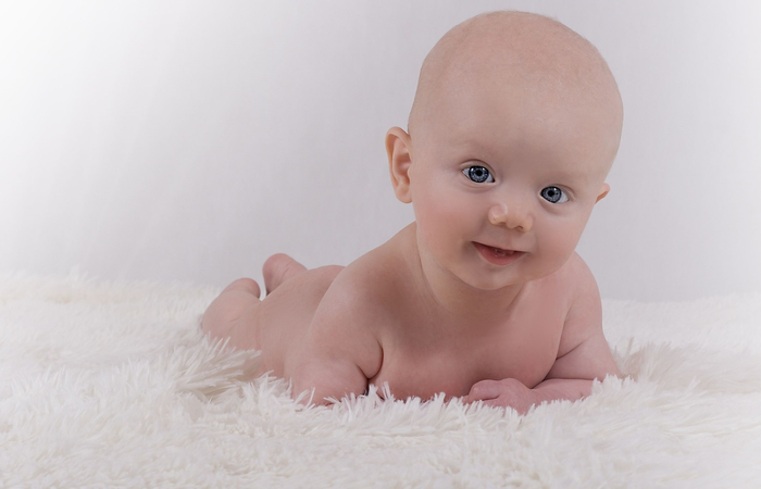 imagen bebé desnudito sobre una alfombra nombres originales de niño: bebé sobre alfombra