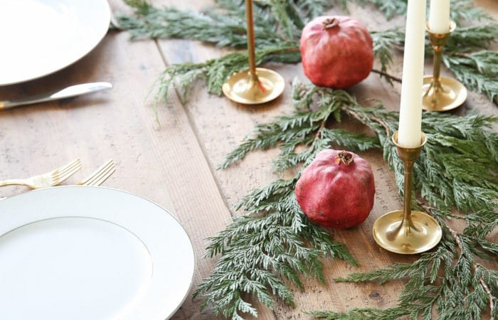 Centro con granadas, ramas y candelabros para la mesa de Navidad Centro con frutas