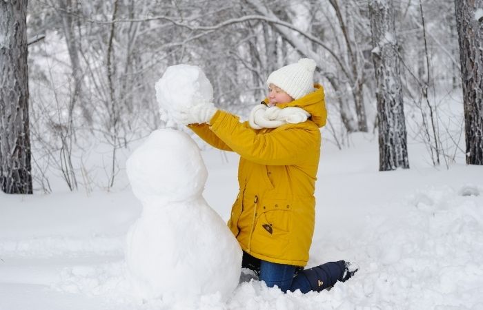 consejos para hacer un muñeco de nieve adolescente haciendo un muñeco de nieve