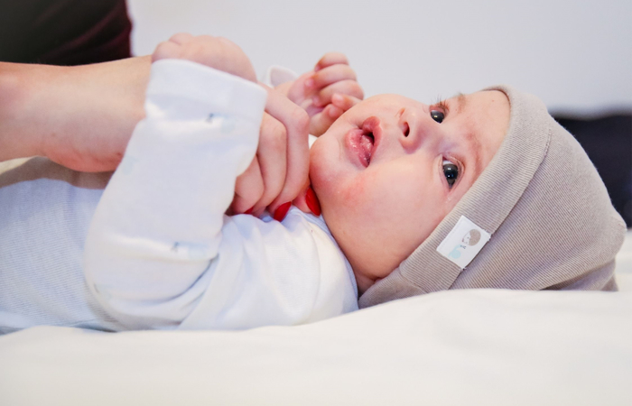 bebé tumbado bebé tumbado mientras su madre lo viste