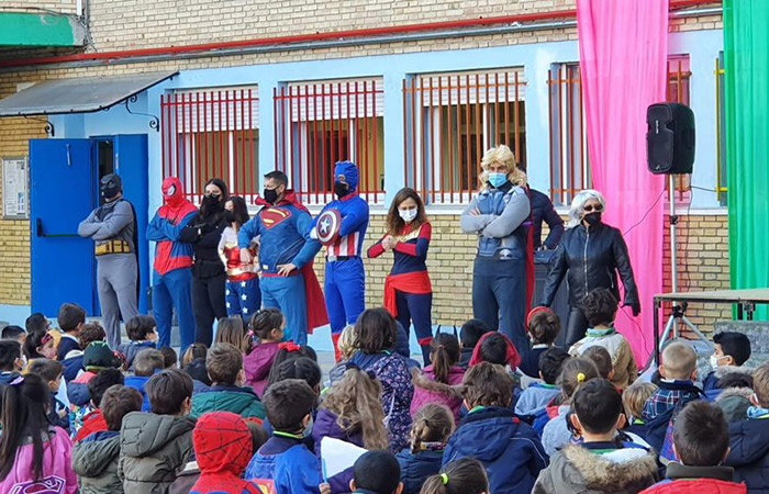 Profesores vestidos de superhéroes en el patio del cole ante sus alumnos animación a la lectura en el colegio: profesores superhéroes