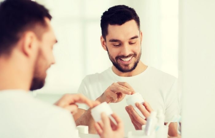 Hombre aplicándose crema facial Protector solar piel sana