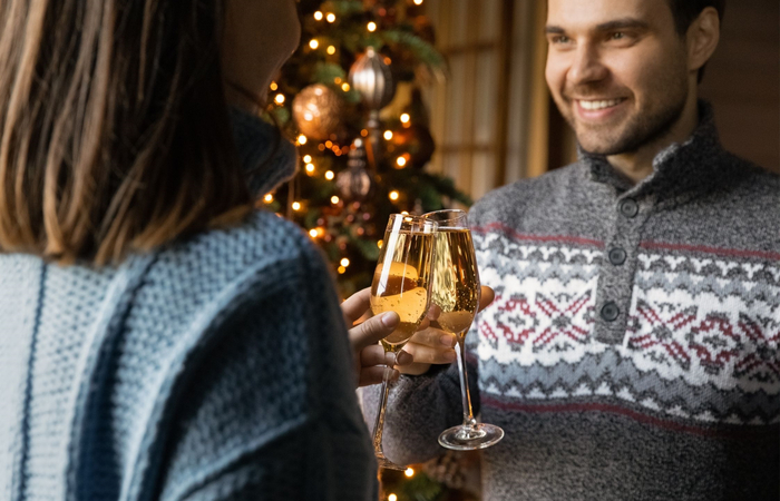 pareja feliz brindando en navidad frases para despedir el año: brindis
