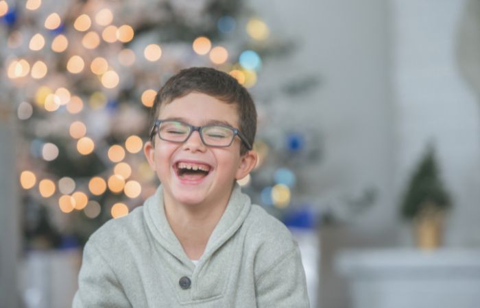 Niño riendo en su casa, en Navidad Frases para despedir el año con humor