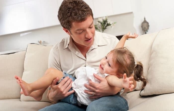 padre sostiene en sus brazos a su hija con un berrinche calmar las rabietas: padre con hija