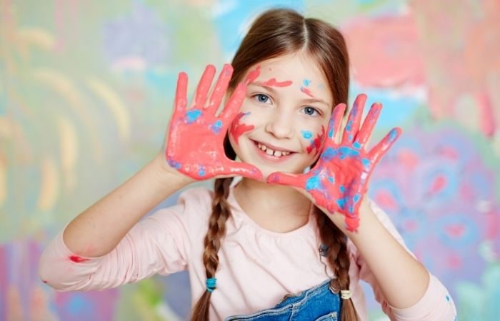 La creatividad de los niños es mayor y mucho más libre Creatividad jóvenes: niña con pintura en las manos