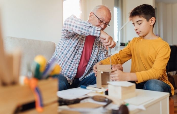 Ayudemos a que nuestro hijo no pierda su creatividad Creatividad: preadolescente con adulto trabajando en una manualidad