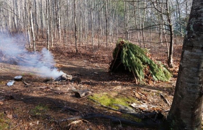 Los preppers aprenden a hacer refugios de supervivencia Preppers: refugio con ramas en el bosque