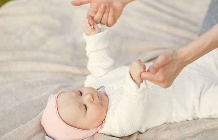 Los buenos reflejos son síntomas de una salud óptima Reflejos: Madre prueba el reflejo de Moro sujetándolo por las manitas
