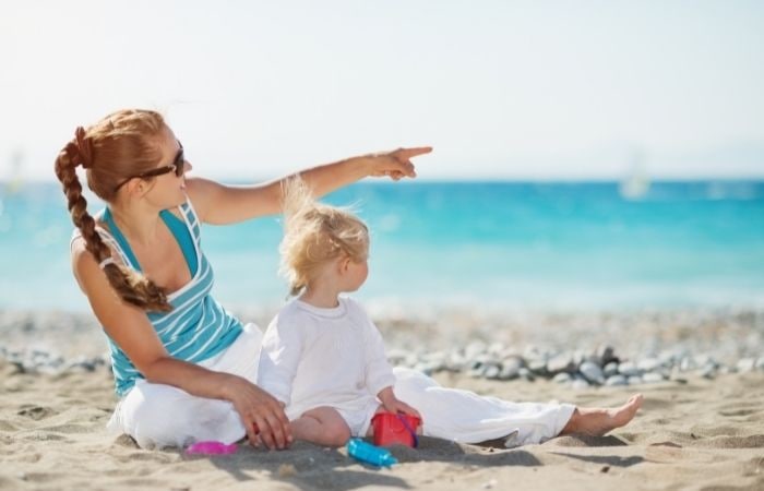 Los niños pueden aprender a señalar viendo tu ejemplo Da ejemplo al señalar, como esta madre señalando en la playa