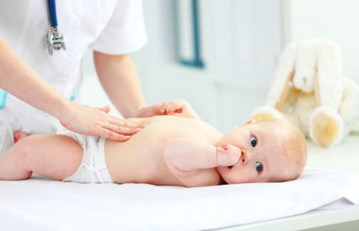 Si el bebé no hace caca y el problema persiste, el pediatra examinará al bebé el bebé no hace caca: pediatra examinando a un bebé