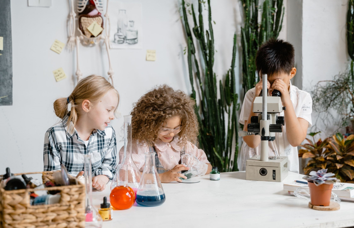 niños experimentando con microscopio niños experimentando