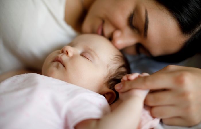 bebé dormido junto a su madre Madre tumbada junto a su bebé dormido