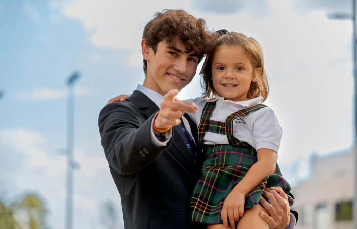 Dos alumnos del colegio, niña pequeña y hermano mayor Highlands School Los Fresnos